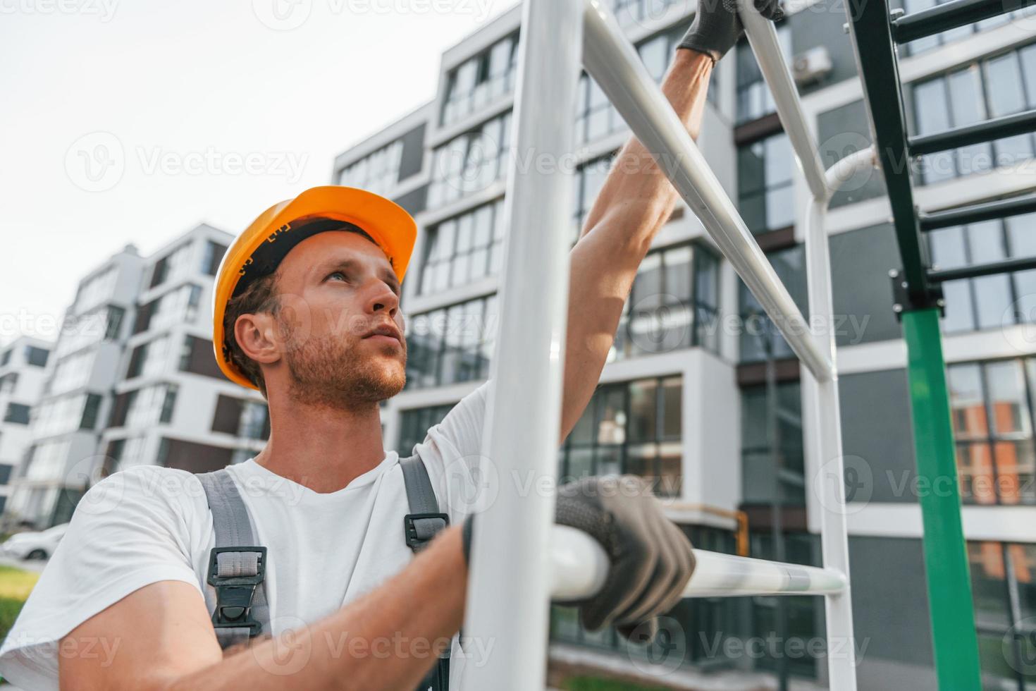 großes Projekt. junger mann, der tagsüber in uniform auf dem bau arbeitet foto