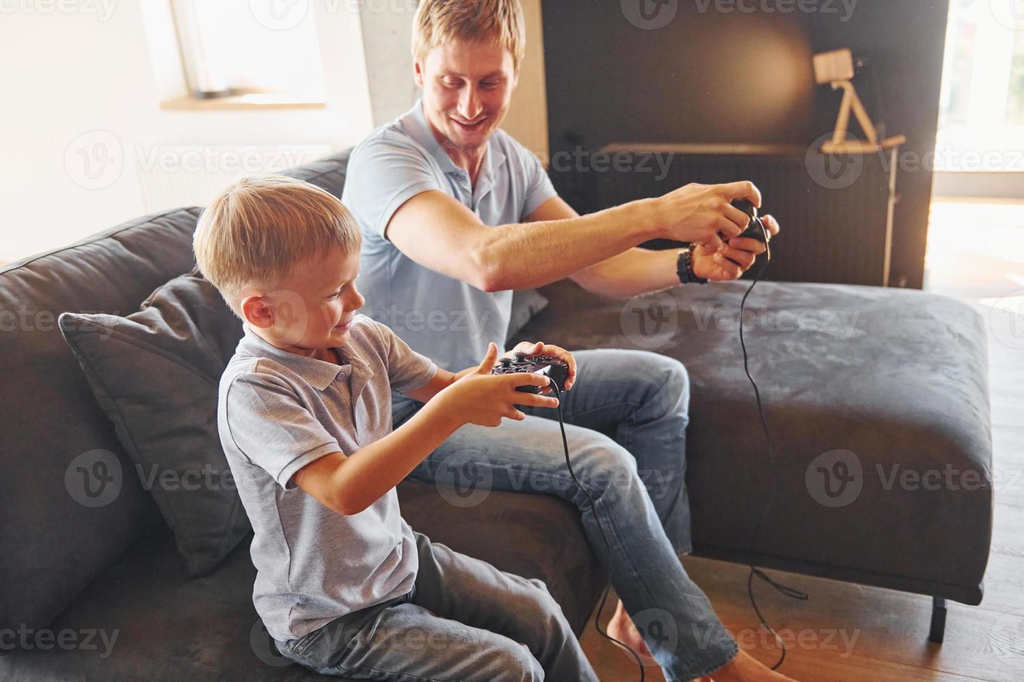 mit Videospiel-Joysticks. Vater und Sohn sind zusammen zu Hause foto