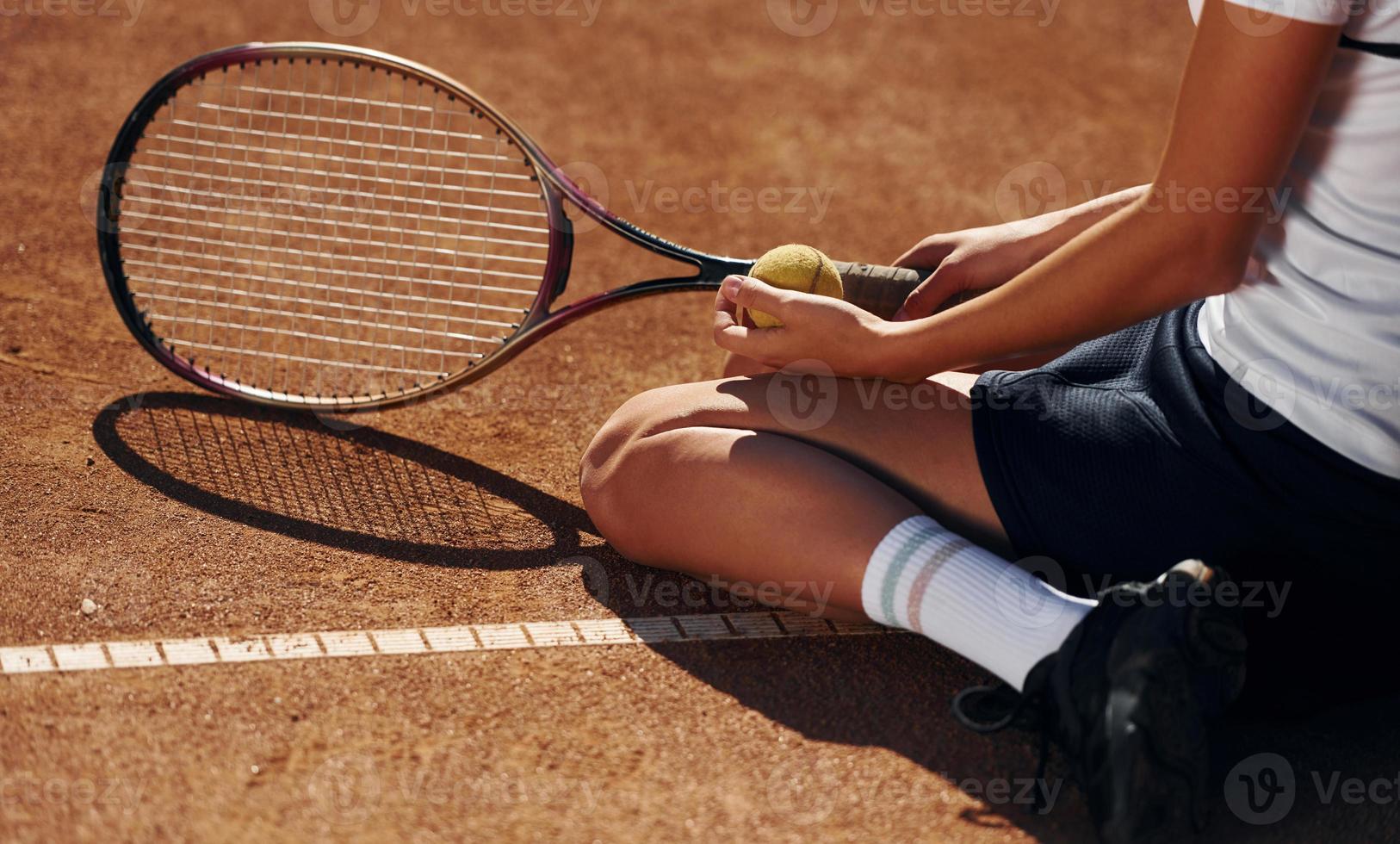 auf dem Boden. Tennisspielerin ist tagsüber auf dem Platz foto