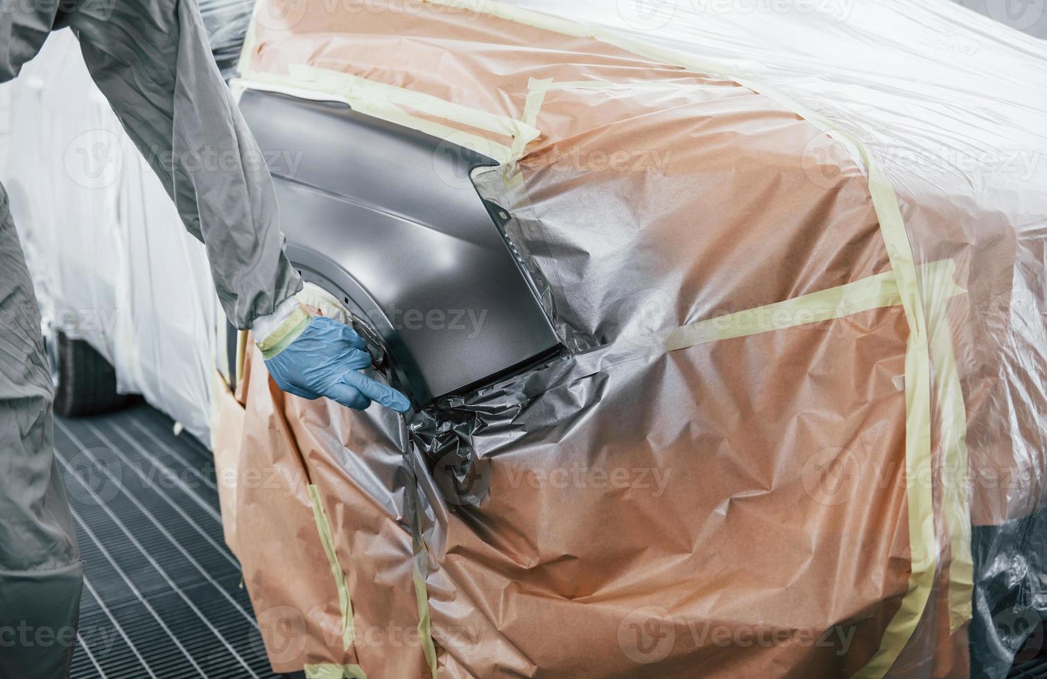 kaukasischer automechaniker in uniform arbeitet in der garage foto