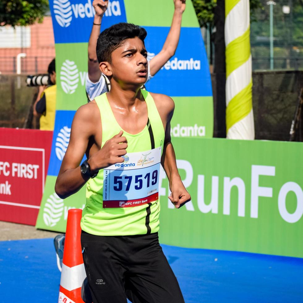 neu delhi, indien - 16. oktober 2022 - vedanta delhi halbmarathonrennen nach covid, bei dem die marathonteilnehmer kurz vor dem überqueren der ziellinie stehen, delhi halbmarathon 2022 foto