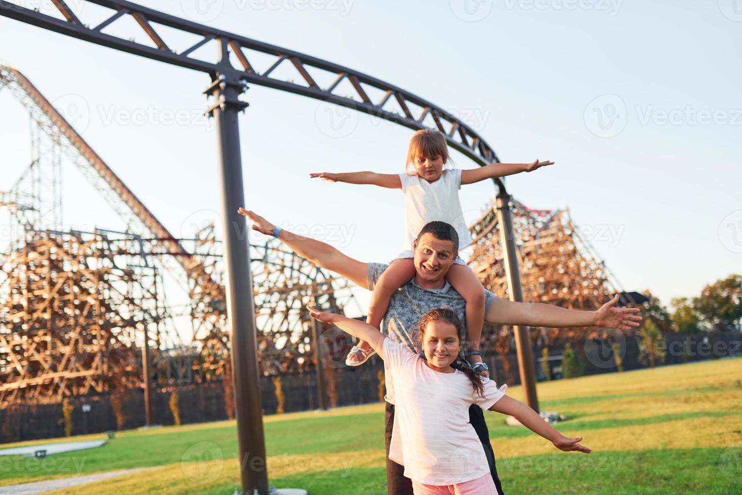 Vater hat tagsüber Spaß mit seinen Töchtern im Kindervergnügungspark foto