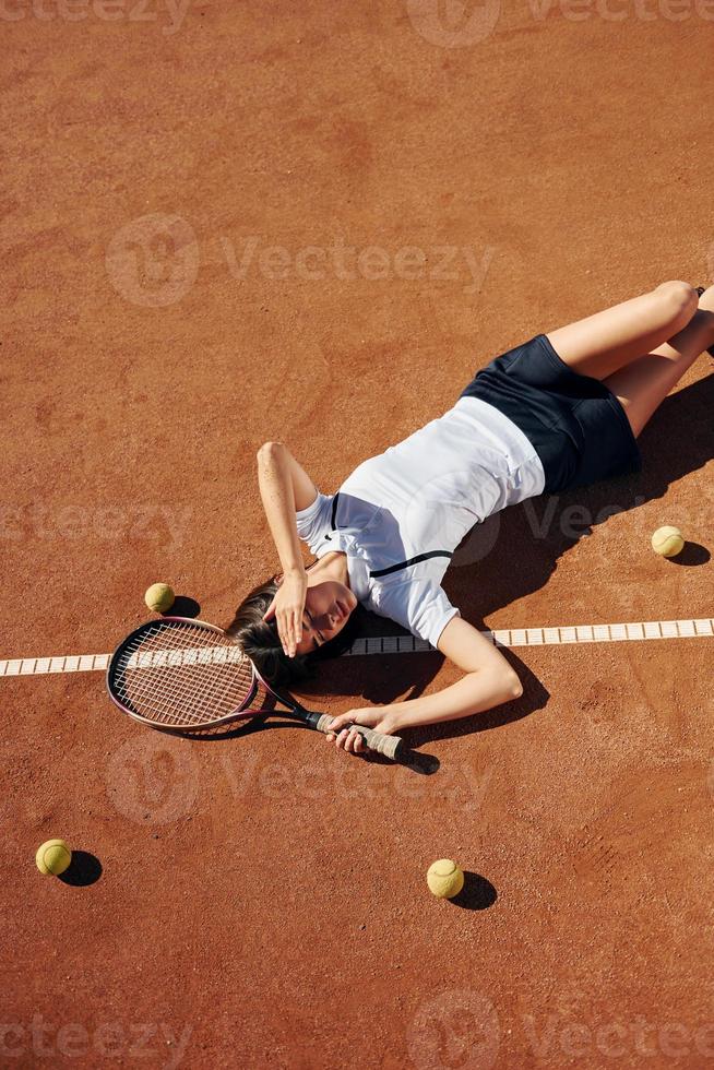 Sicht von oben. Tennisspielerin ist tagsüber auf dem Platz foto