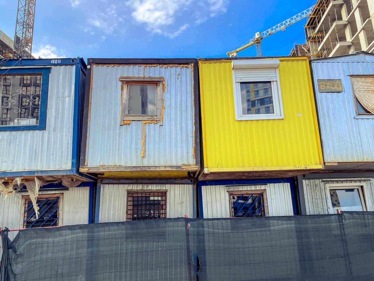 Haus für arme Leute. temporäre Wohngebäude. Häuser für Bauherren aus Waggons mit Fenstern in zwei Reihen. helle, gelb und grau gestrichene Blockhäuser foto