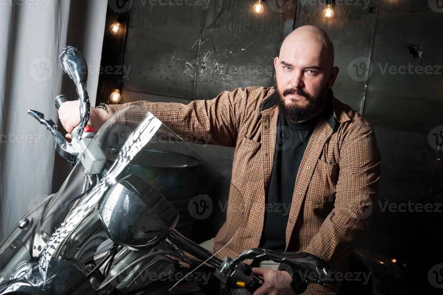 Porträt eines Mannes in einem Hemd mit Bart auf einem Motorrad foto