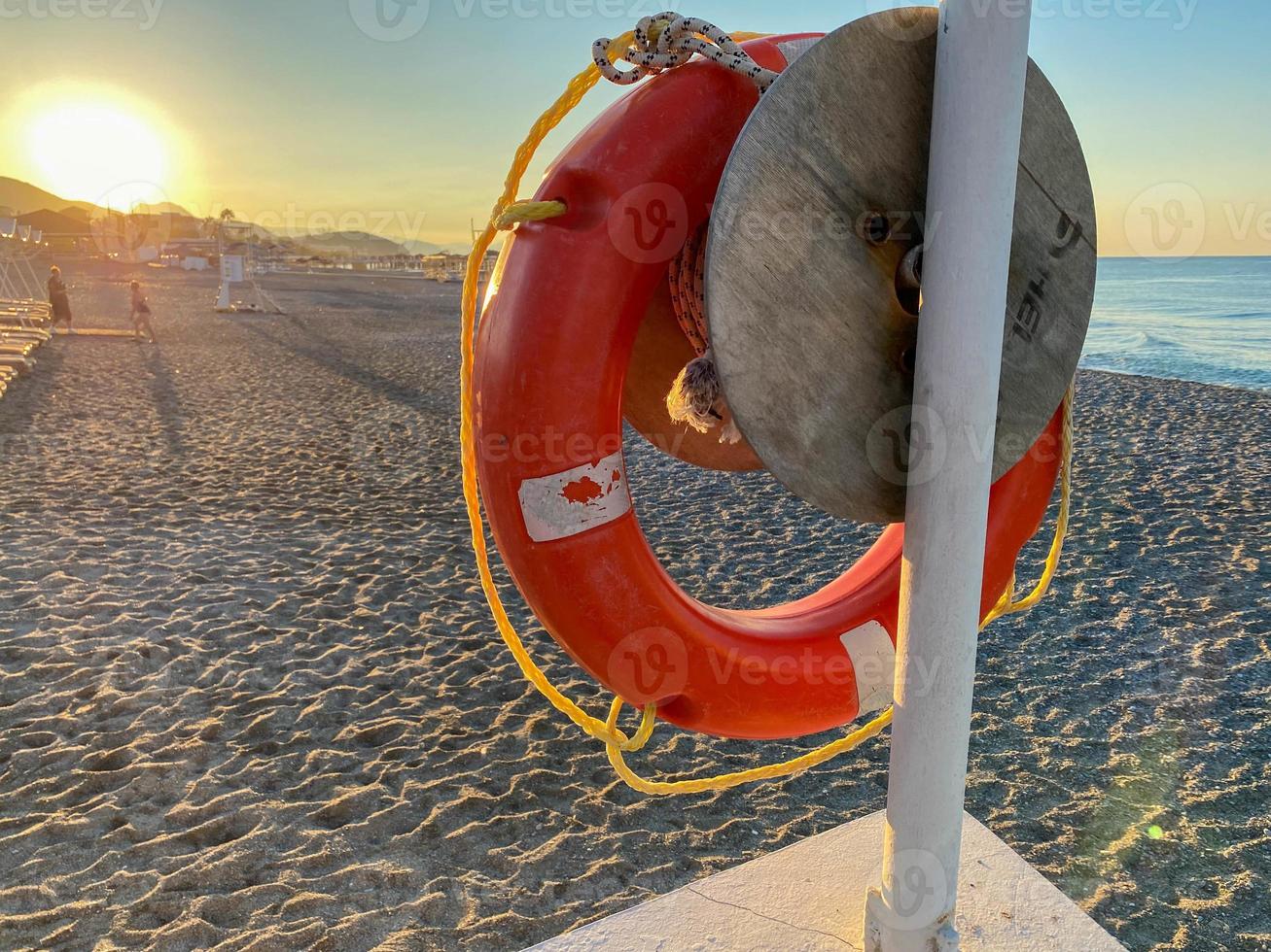 runde, nicht sinkende rote Rettungsboje zur Sicherheit, um das Leben von Ertrinkenden zu retten Touristen am Strand in einem warmen östlichen tropischen Land Southern Paradise Resort foto