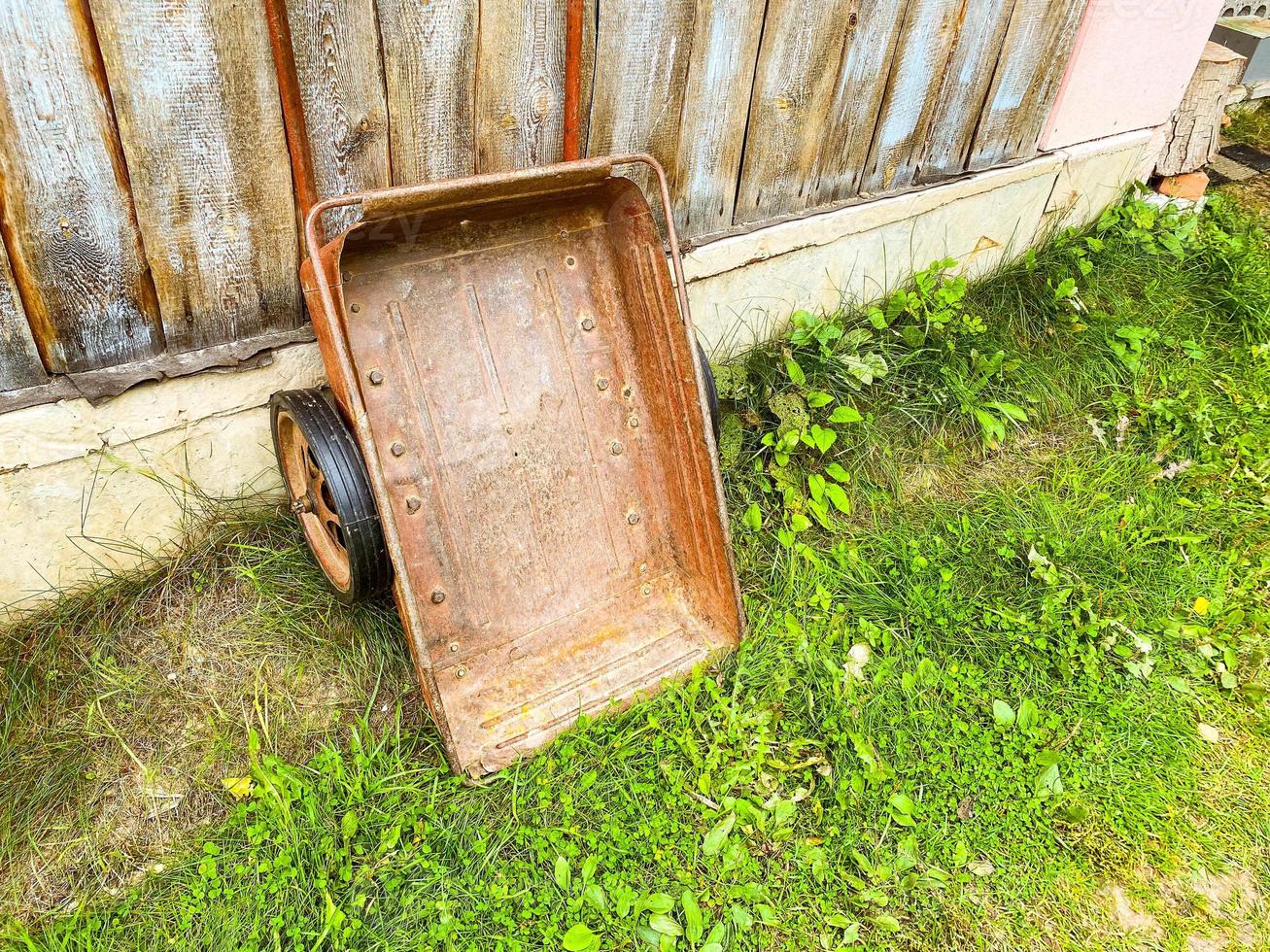 Einkaufswagen und Schaufel aus nächster Nähe. ein Gerät zum Transportieren von Fracht-Sand, Ton, Torf, Humus, Erde. Gartengeräte auf Rädern für Garten, Garten und Landhaus. foto