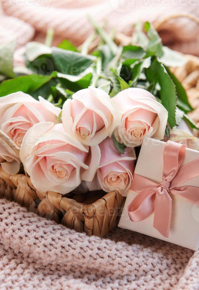 tablett mit strauß schöner rosa rosen und geschenkbox auf dem bett. foto