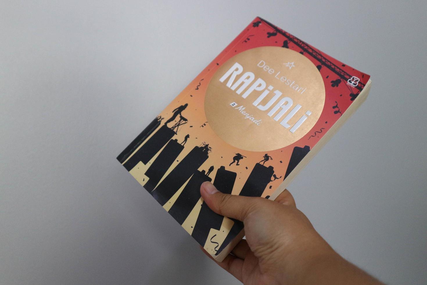 west java, indonesien im juli 2022. eine hand hält einen roman namens rapijali second edition, der von der berühmten schriftstellerin dee lestari geschrieben wurde foto