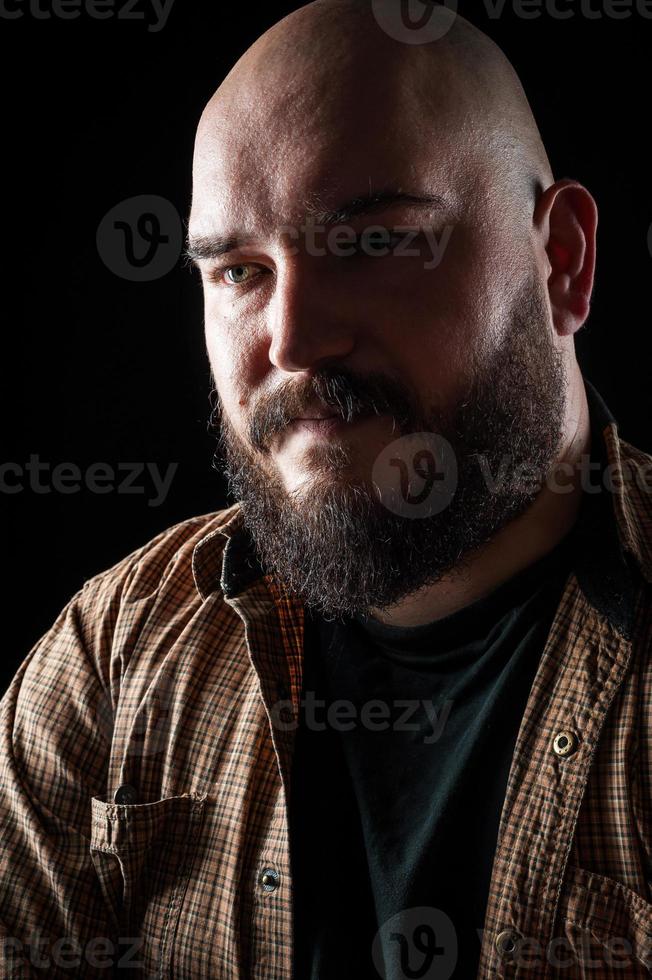 Porträt eines glatzköpfigen Mannes in einem Hemd mit Bart foto