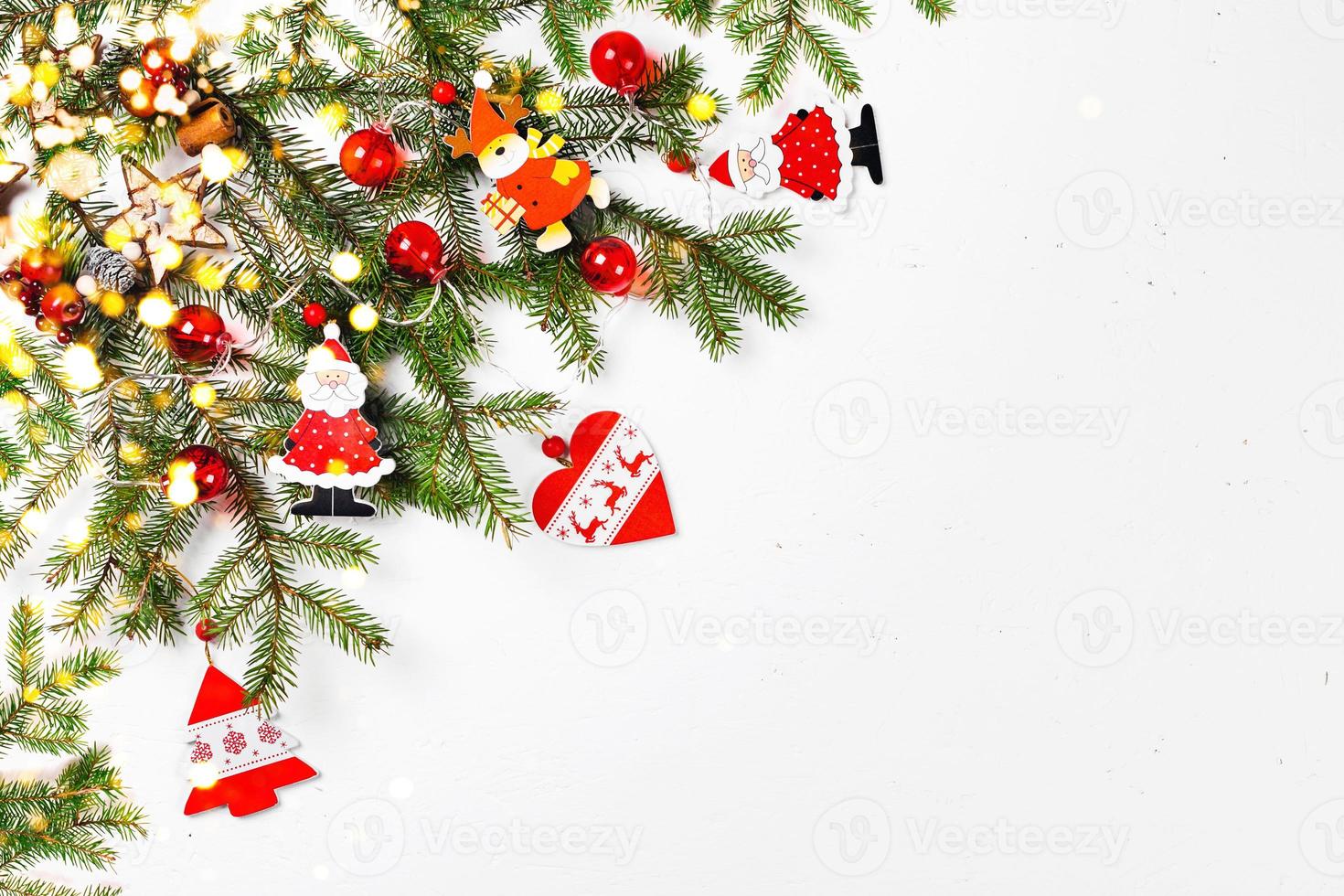 weihnachtshintergrund mit tannenzweigen, weihnachtsspielzeug und lichtern foto