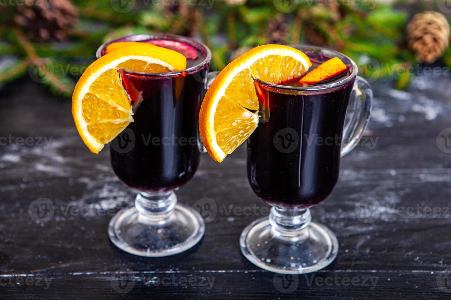 Glas köstlicher Glintwein oder Glühwein, Zimt, Faden auf Vintage-Holzhintergrund. foto