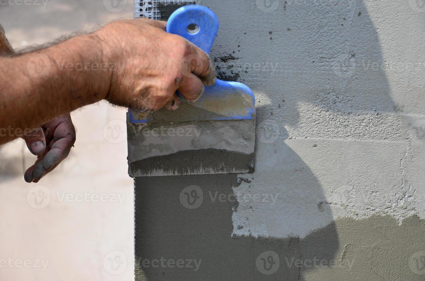 hände eines alten handwerkers mit wandputzwerkzeugen, die haus renovieren. Gipser renovieren Außenwände und Ecken mit Spachtel und Gips. Wanddämmung. Bauabschlussarbeiten foto