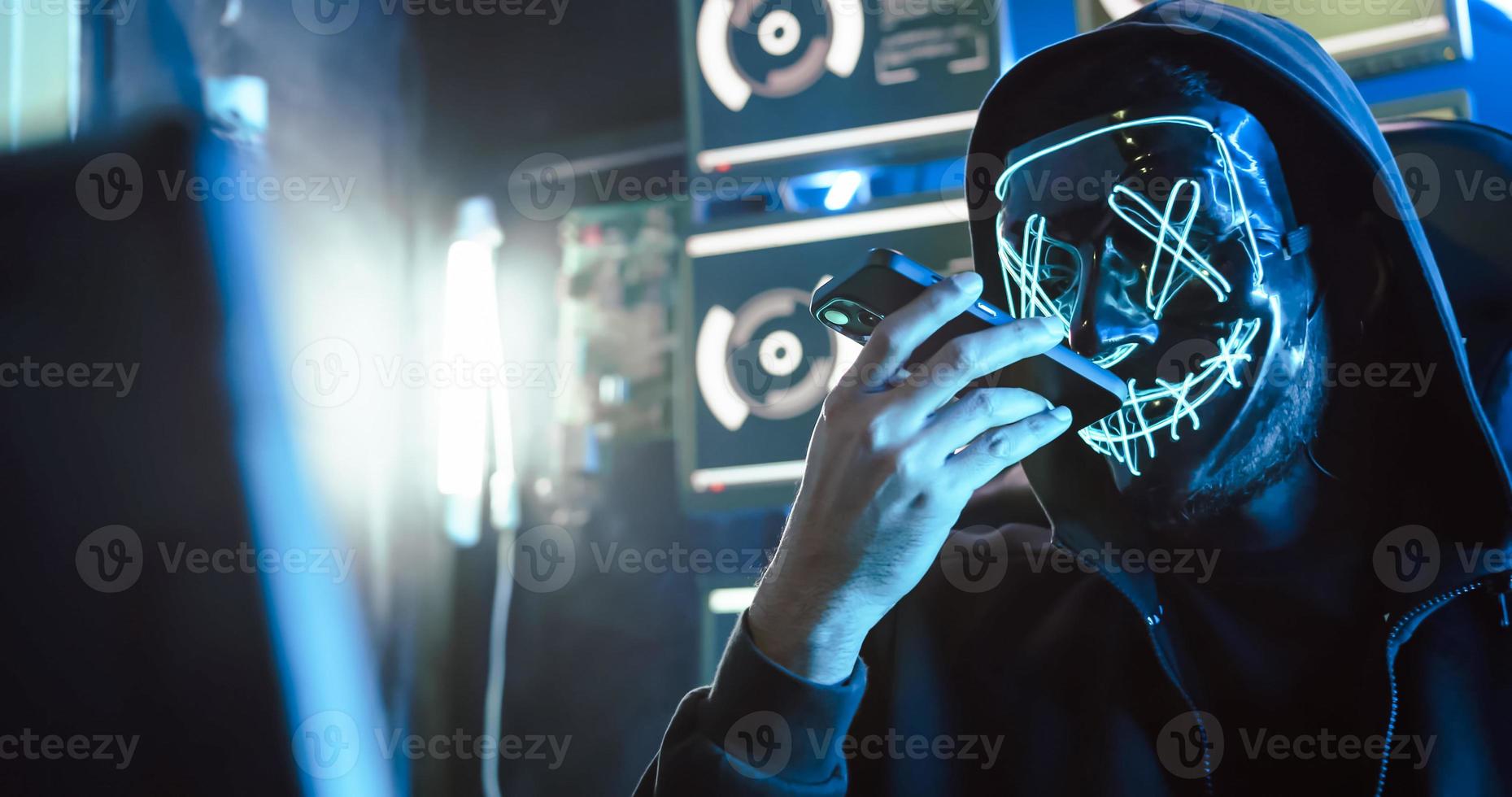 Ein Hacker, der eine Maske trägt, um sein Gesicht zu bedecken, verwendet Computer, um Daten zu hacken, um Lösegeld von Opfern zu erhalten. foto