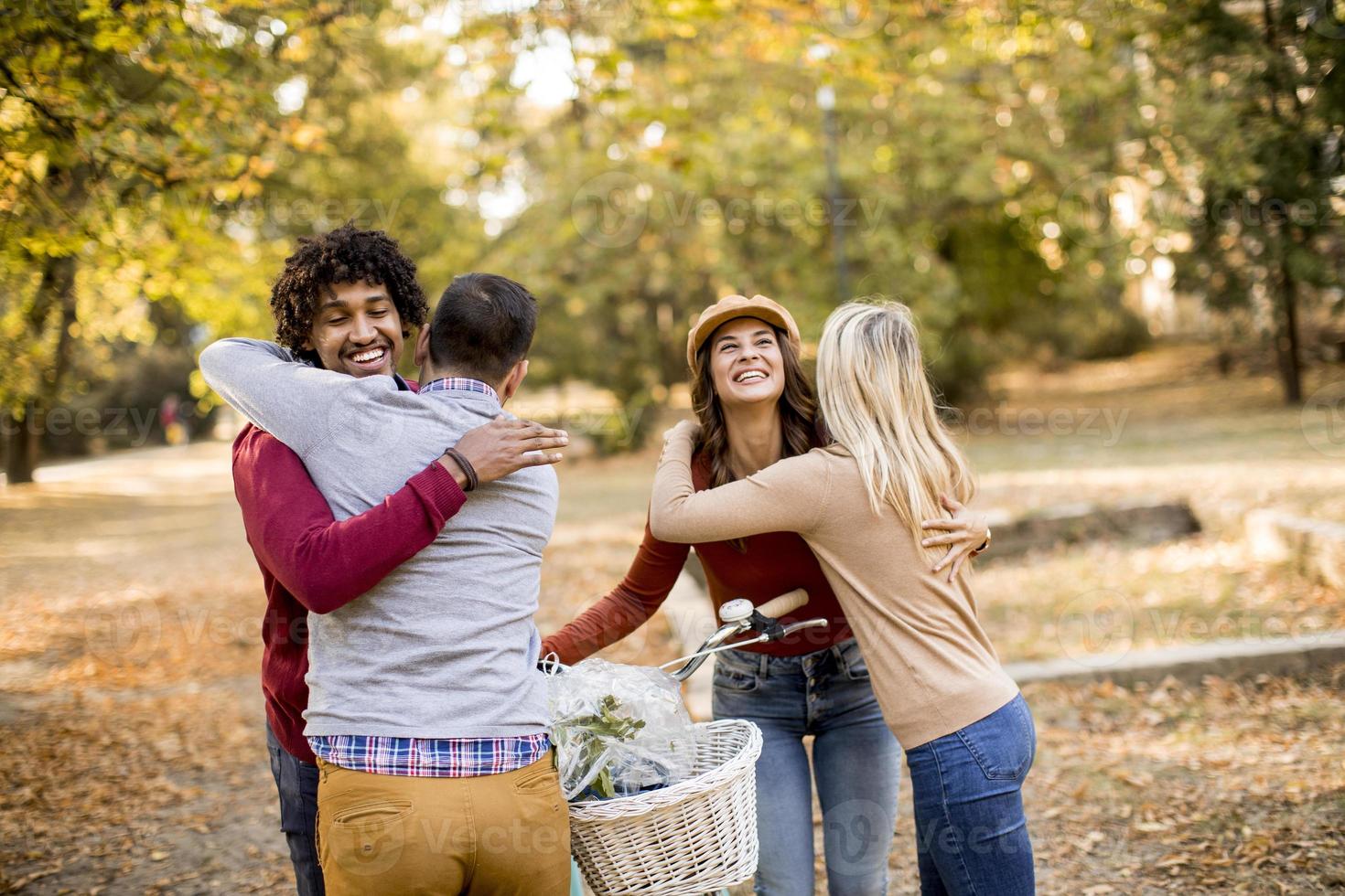 gemischtrassige junge Leute, die im Herbstpark spazieren gehen foto