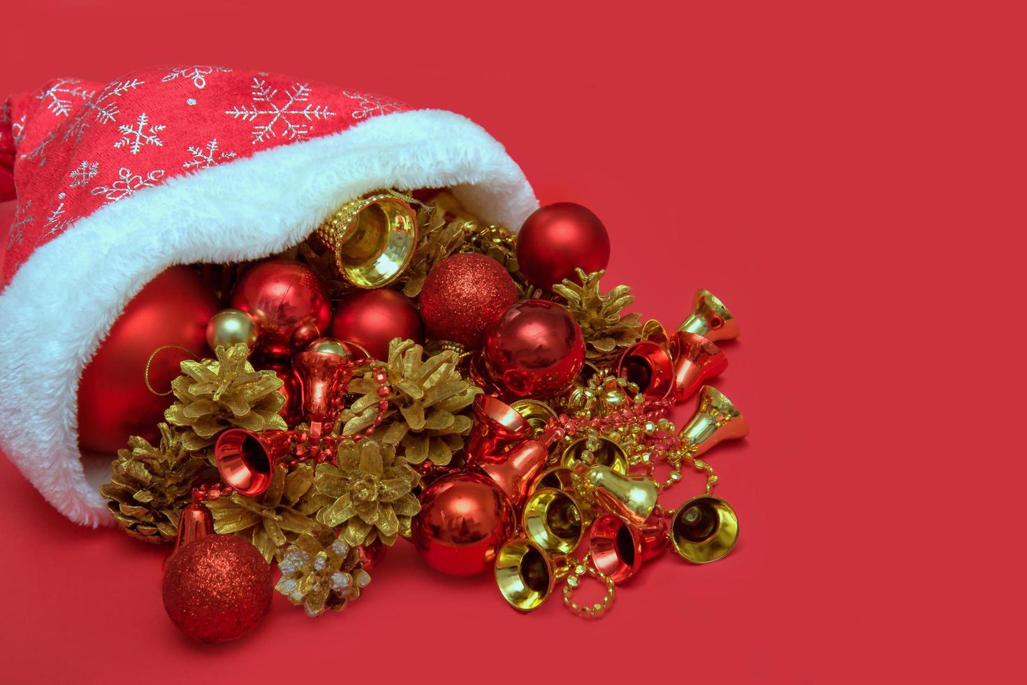 weihnachtsspielzeug in nikolausmütze auf rotem hintergrund foto