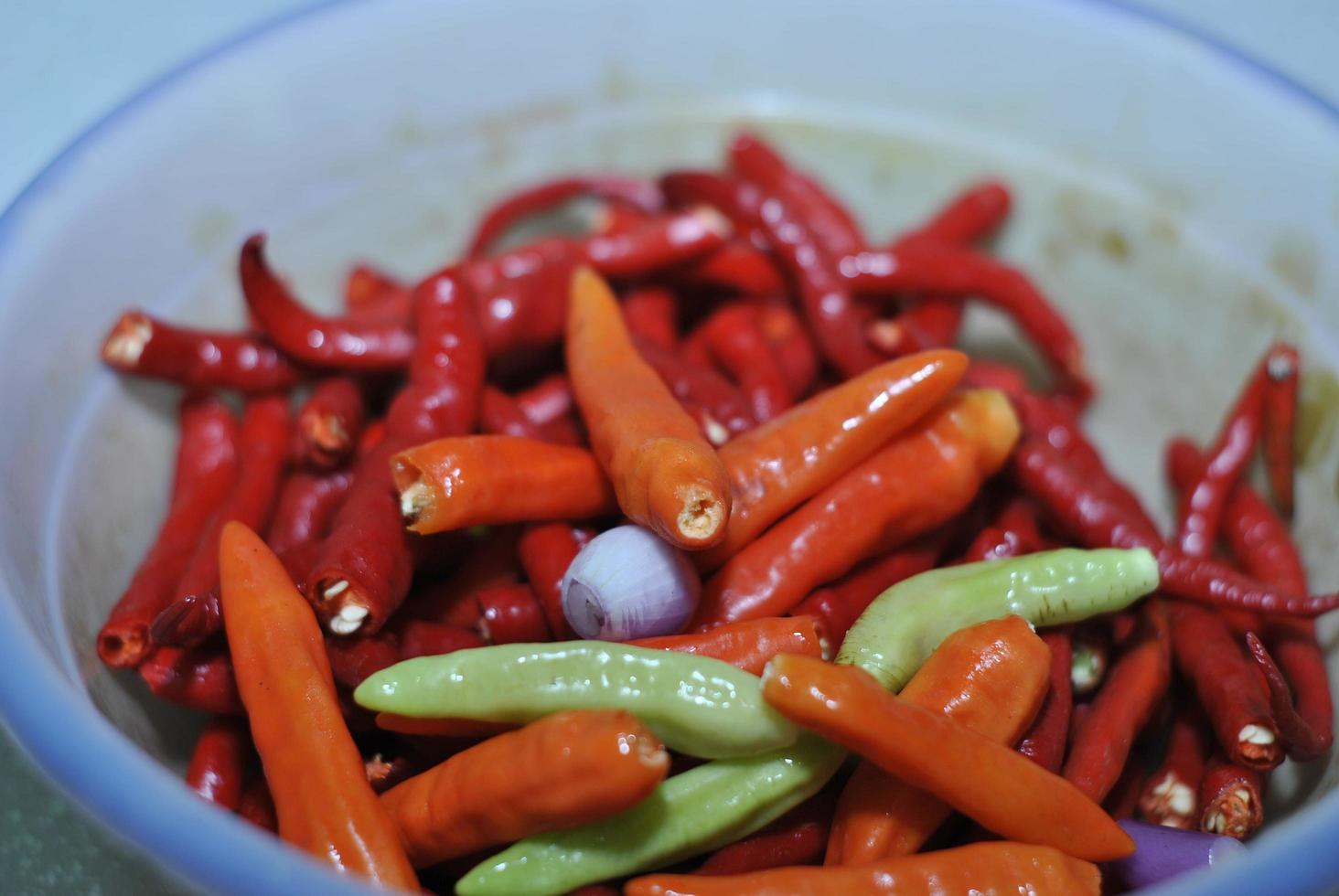 würzige grüne Chilis und würzige rote Chilis mit Schalenhintergrund foto