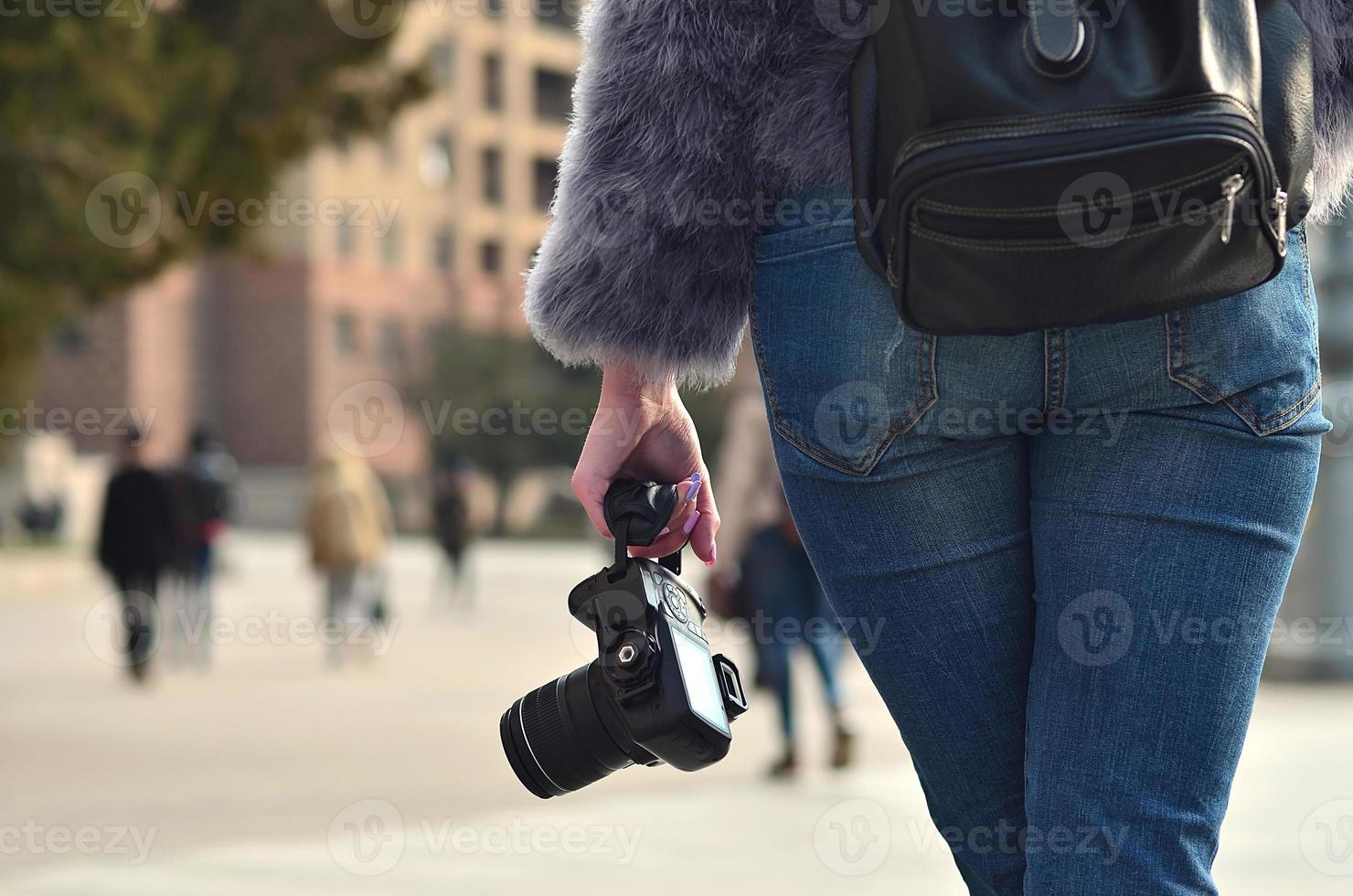 Rückansicht eines Mädchens mit einer Digitalkamera auf einer überfüllten Straße foto