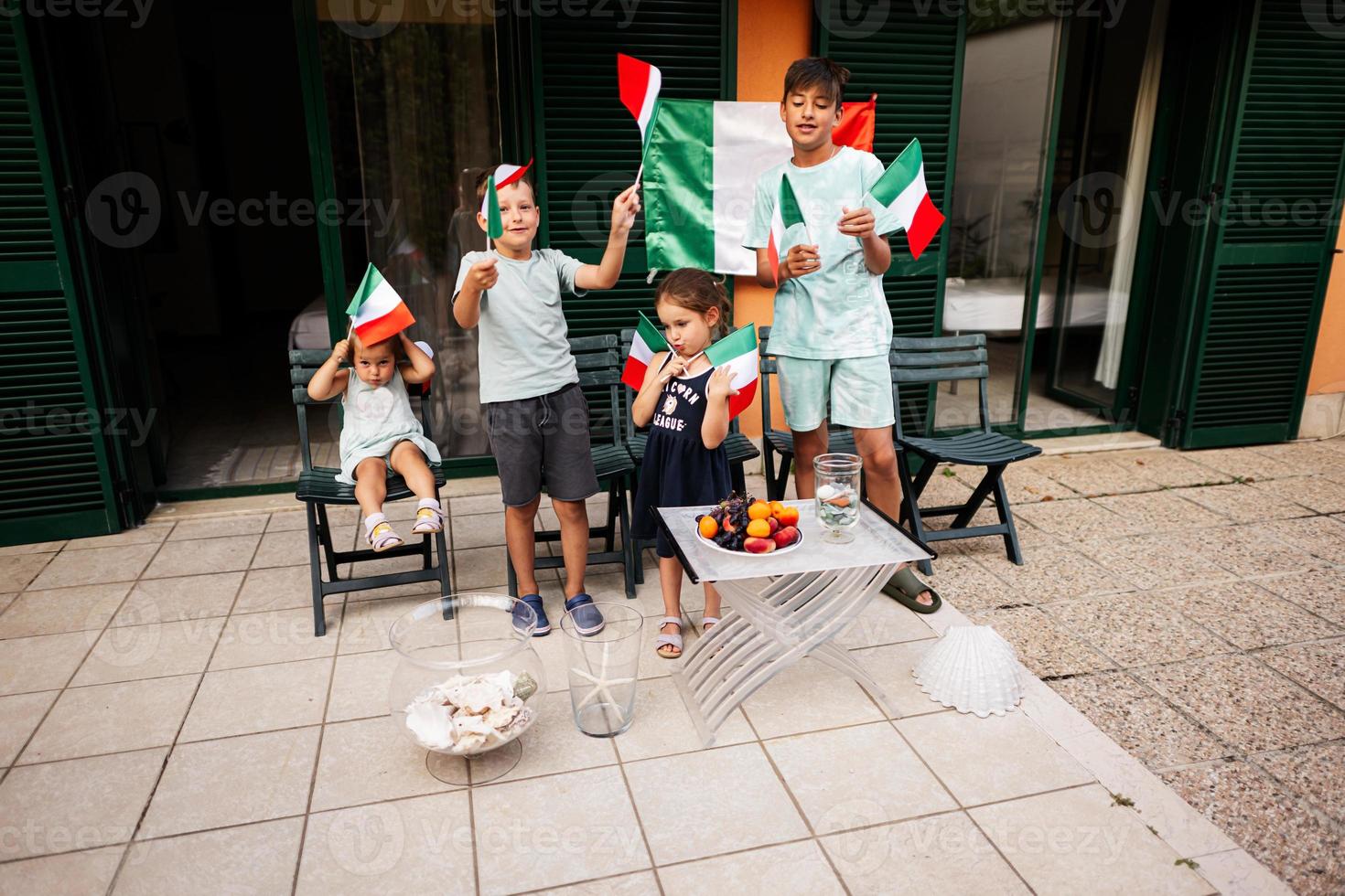 glückliche vier kinder mit italienischen flaggen, die den tag der republik in italien feiern. foto