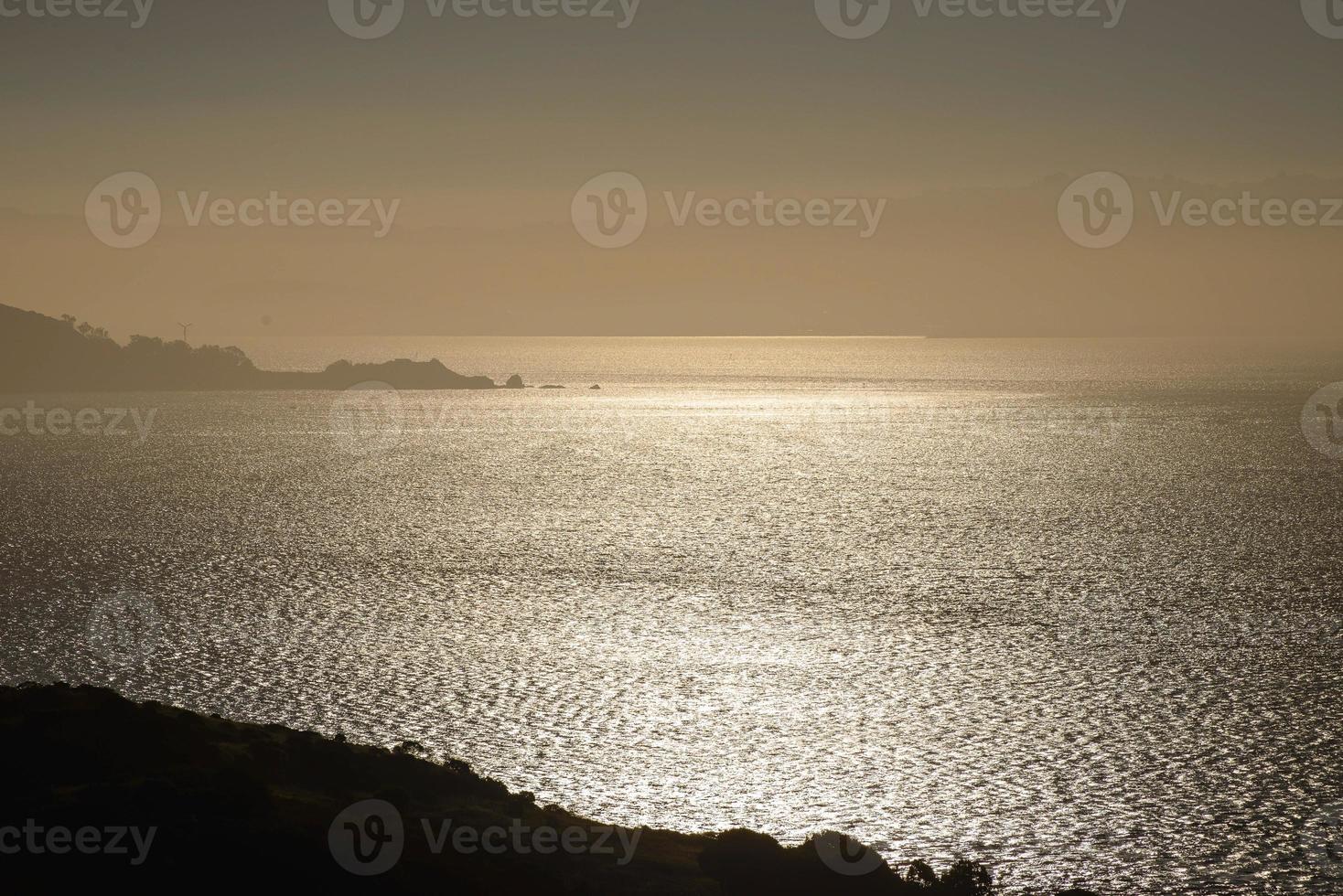 Gesprenkeltes Licht spiegelt sich in einem frühmorgendlichen Bild auf dem unruhigen Wasser. foto