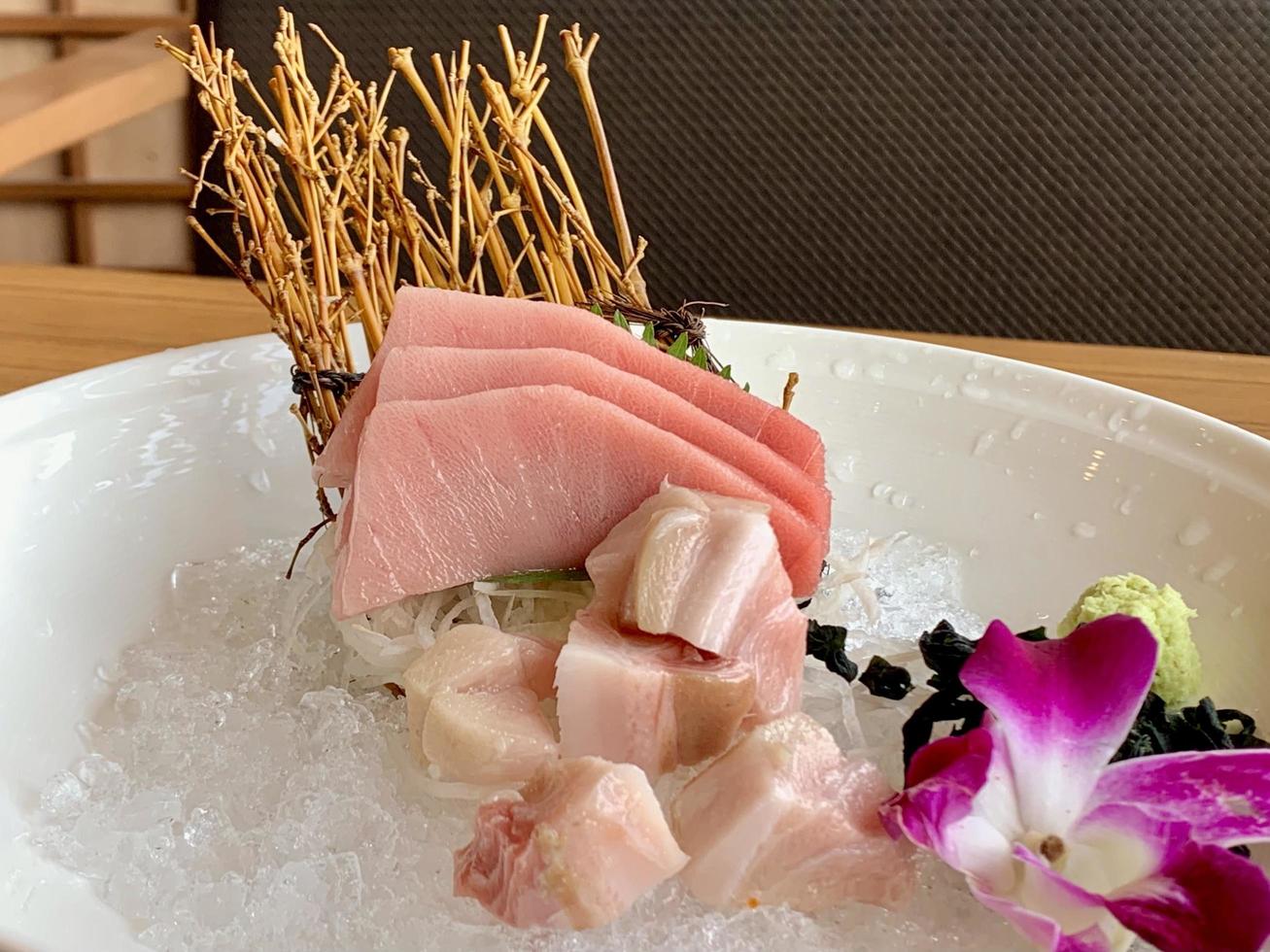 verschiedene Menüs, Sushi, Sashimi, Nigiri, gebratenes Schweinefleisch und Miso-Suppe. sashimi, chutoro sashimi, japanische essensstäbchen und wasabi auf dem schwarzen tisch, japanischer essensstil. verwischt den Fokus. foto