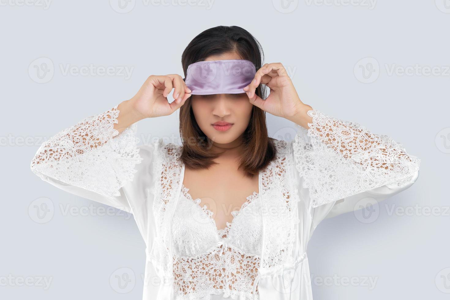 asiatische frau nimmt eine schlafmaske ab foto