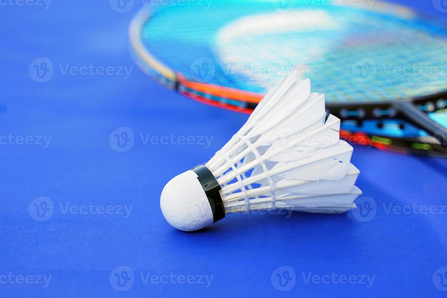 Weißer Federball auf blauem Hintergrund, unscharfer Badmintonschlägerhintergrund. weicher und selektiver Fokus. foto