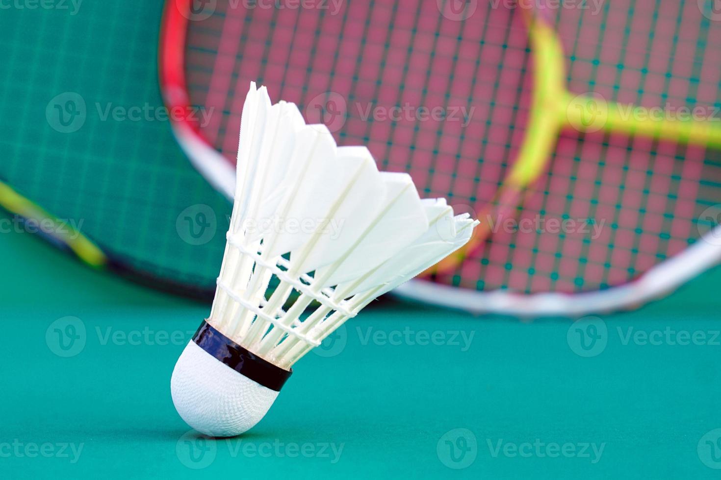 Weißer Federball auf grünem Hintergrund, unscharfer Badmintonschlägerhintergrund. weicher und selektiver Fokus. foto