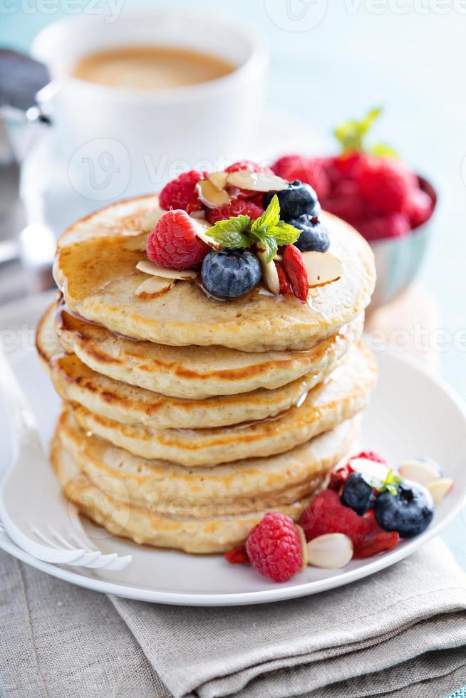 Flauschige Haferflockenpfannkuchen stapeln sich mit frischen Beeren foto