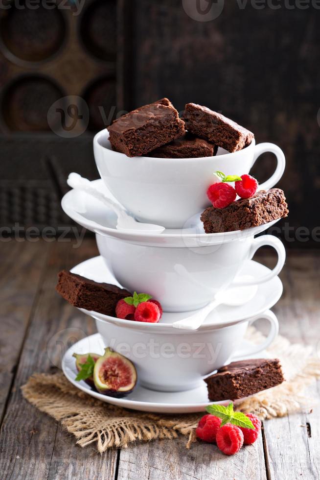 Brownies in gestapelten Kaffeetassen mit Schokoladensauce foto