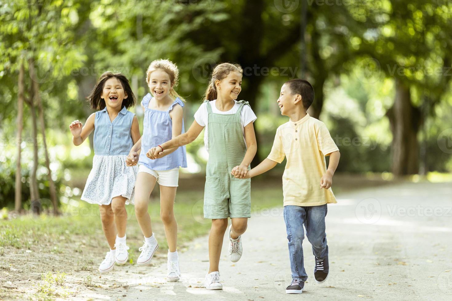 gruppe asiatischer und kaukasischer kinder, die spaß im park haben foto