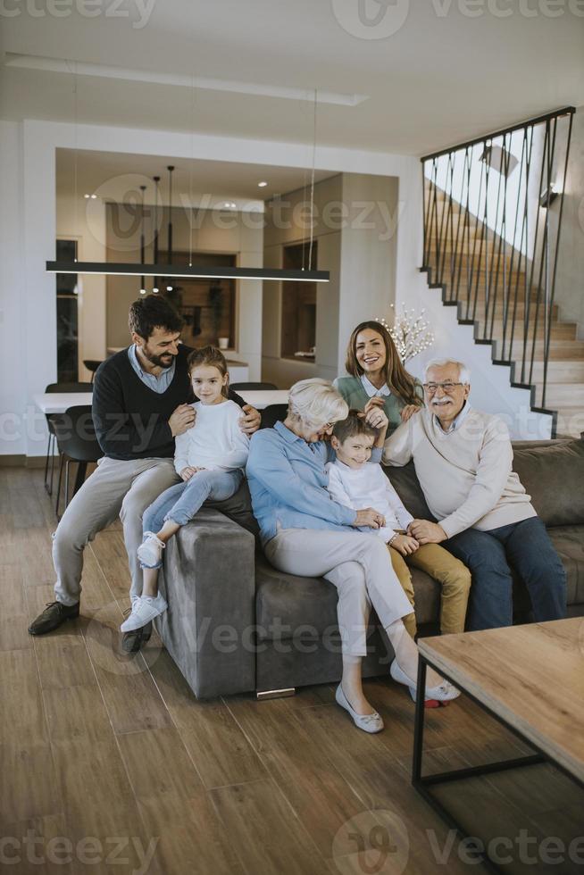 Familie mit mehreren Generationen, die zu Hause auf dem Sofa sitzt foto