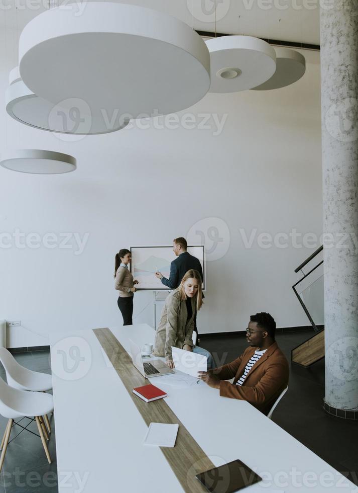 Gruppe multiethnischer Geschäftsleute, die zusammenarbeiten und ein neues Projekt für ein Meeting im Büro vorbereiten foto