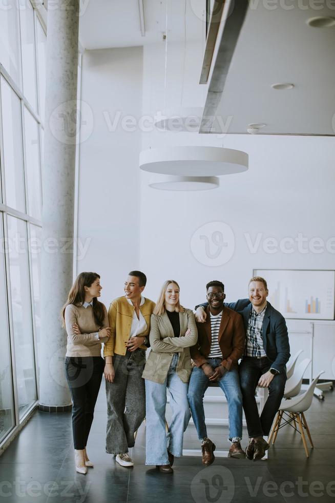 Gruppe positiver Geschäftsleute, die im Büro zusammenstehen foto