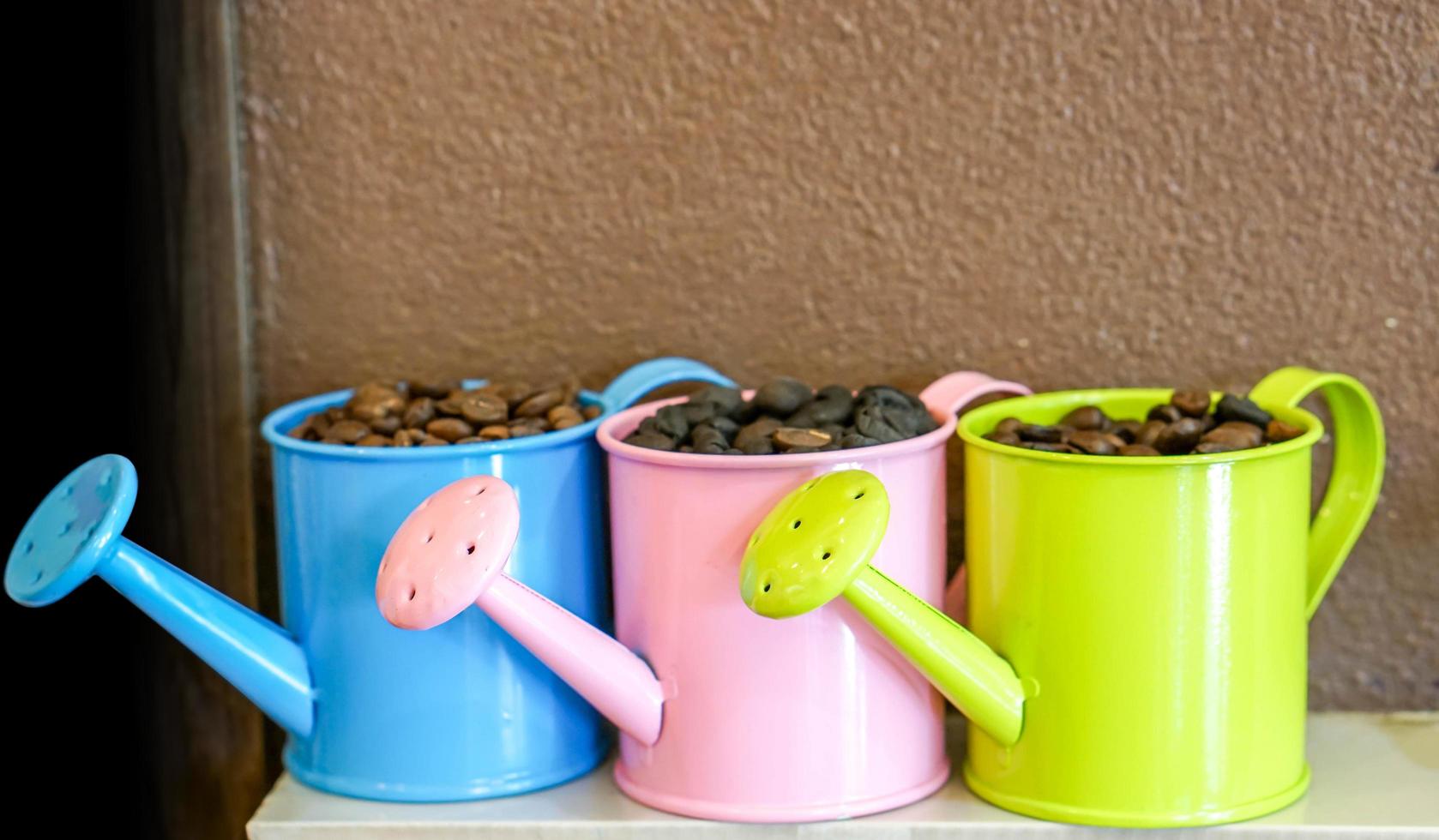 Kaffeebohne im bunten kleinen Dekorationsduschtopf auf Wandhintergrund. foto