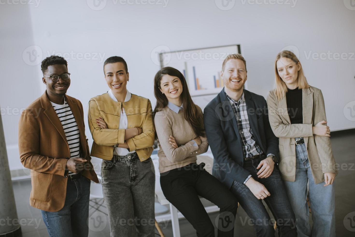 Gruppe positiver Geschäftsleute, die im Büro zusammenstehen foto