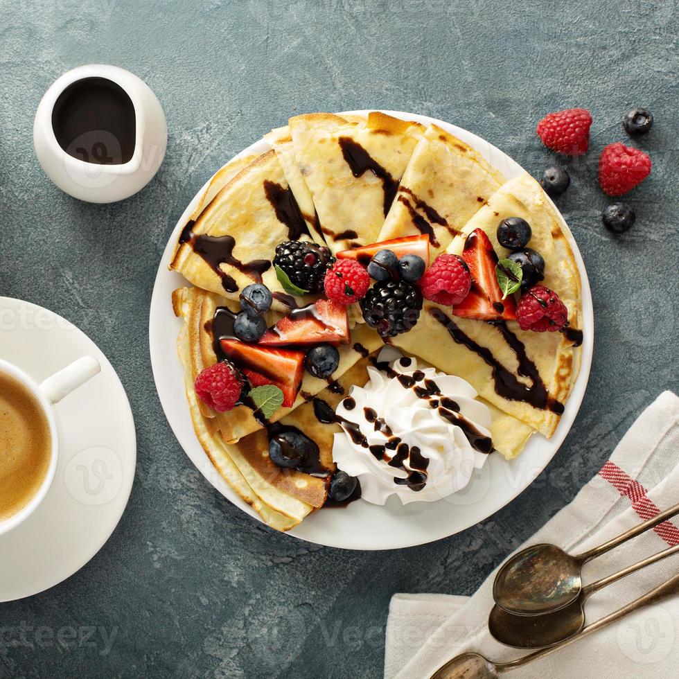 dünne Crêpes mit Schlagsahne und Beeren foto