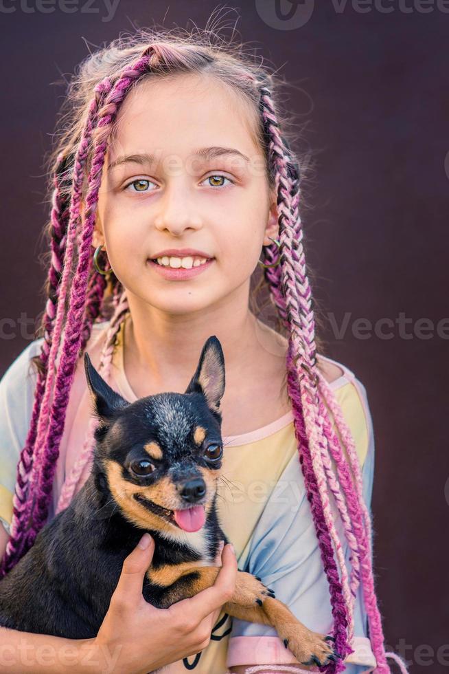 ein junges Mädchen mit einem Hund im Arm. Das kleine Mädchen hatte einen Chihuahua als Haustier. foto