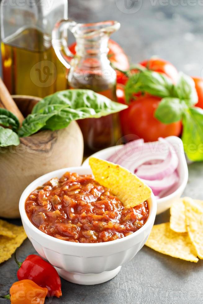 hausgemachte würzige Tomatensalsa mit Gemüse und Olivenöl foto