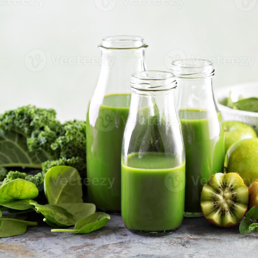 grüner Saft in Glasflaschen foto