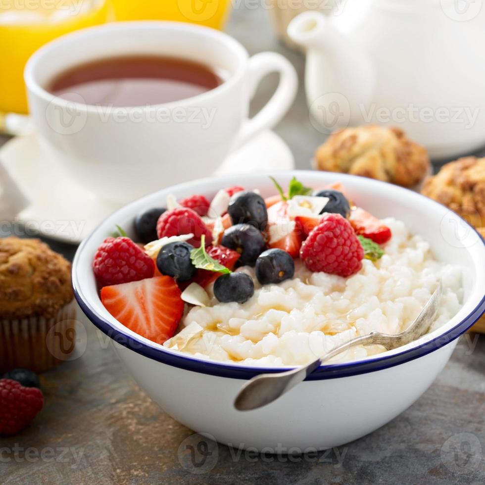 Milchreis mit frischen Beeren und Kokosnuss zum Frühstück foto