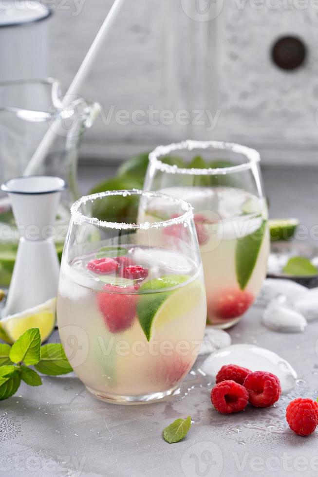 kalter sommercocktail mit limetten und himbeere foto