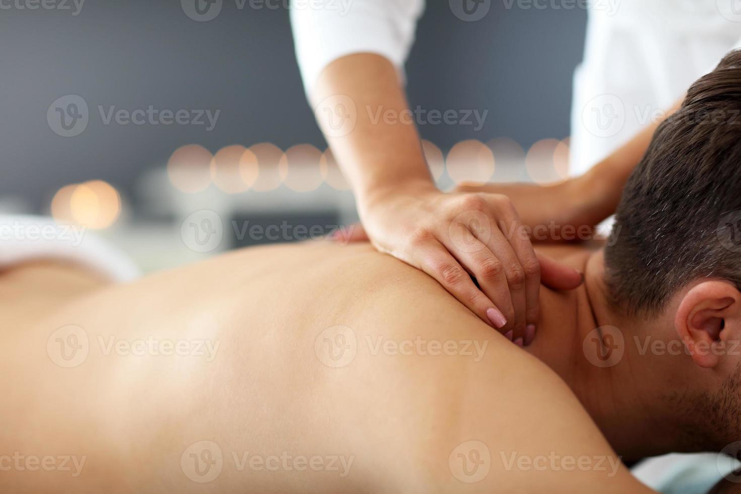 Schöner Mann mit Massage im Spa-Salon foto