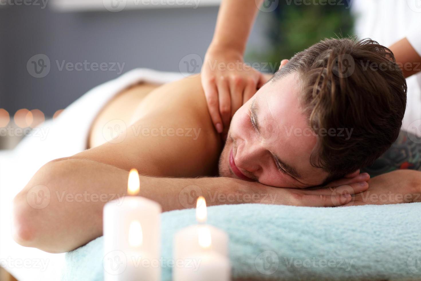 Schöner Mann mit Massage im Spa-Salon foto