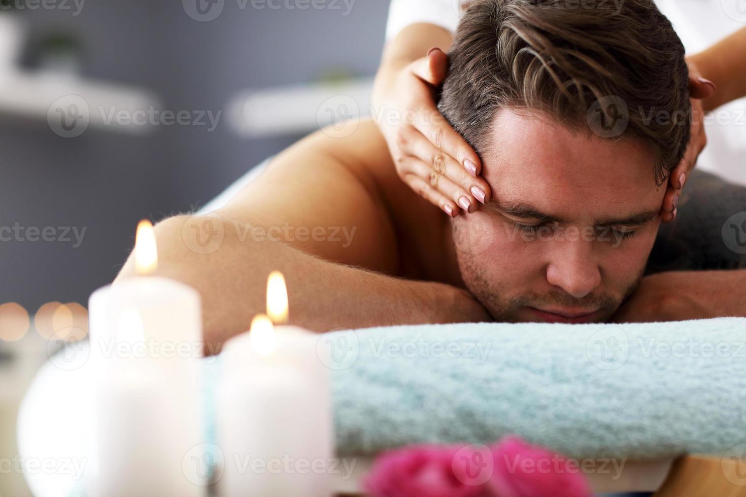 Schöner Mann mit Massage im Spa-Salon foto