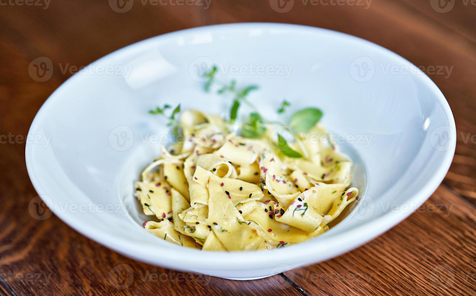 frische Nudeln mit cremiger Sauce auf weißem Teller foto