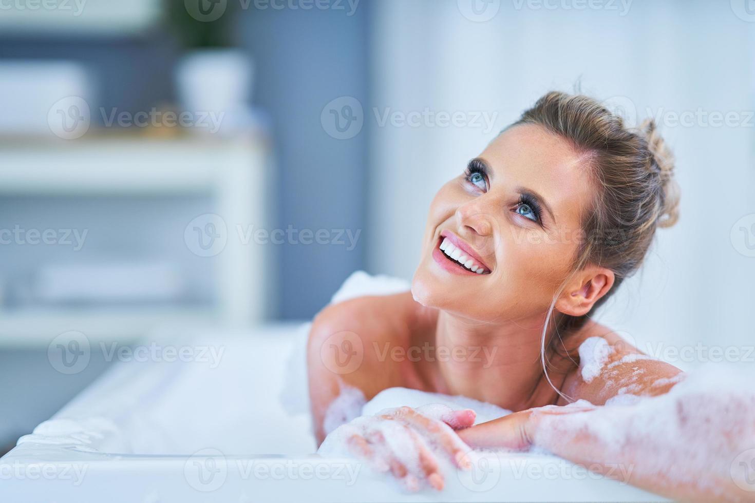 Nahaufnahmeporträt einer jungen Frau, die in der Badewanne sich entspannt foto