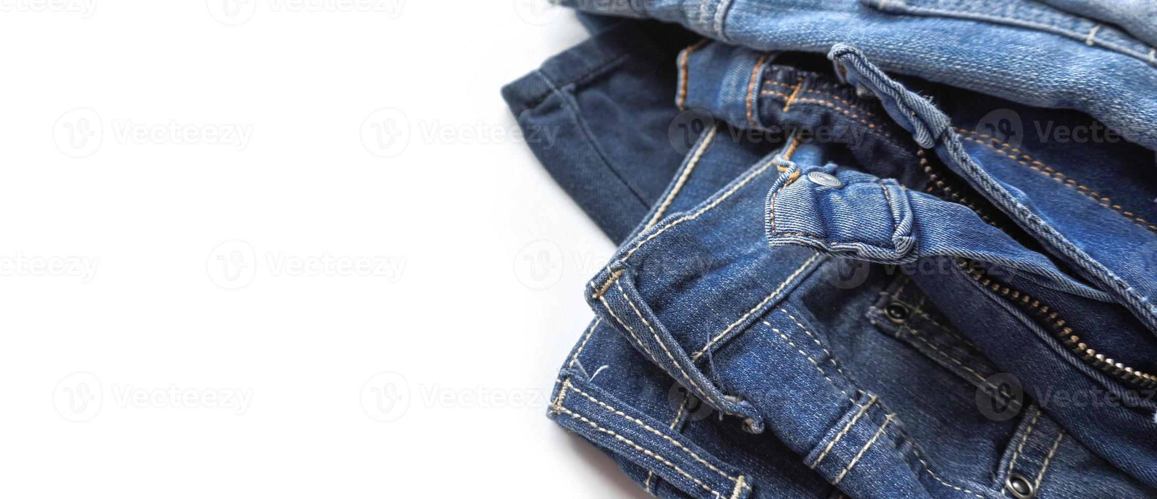 Denim-Jeans in verschiedenen Farbtönen auf weißem Hintergrundbanner mit Kopierraum foto