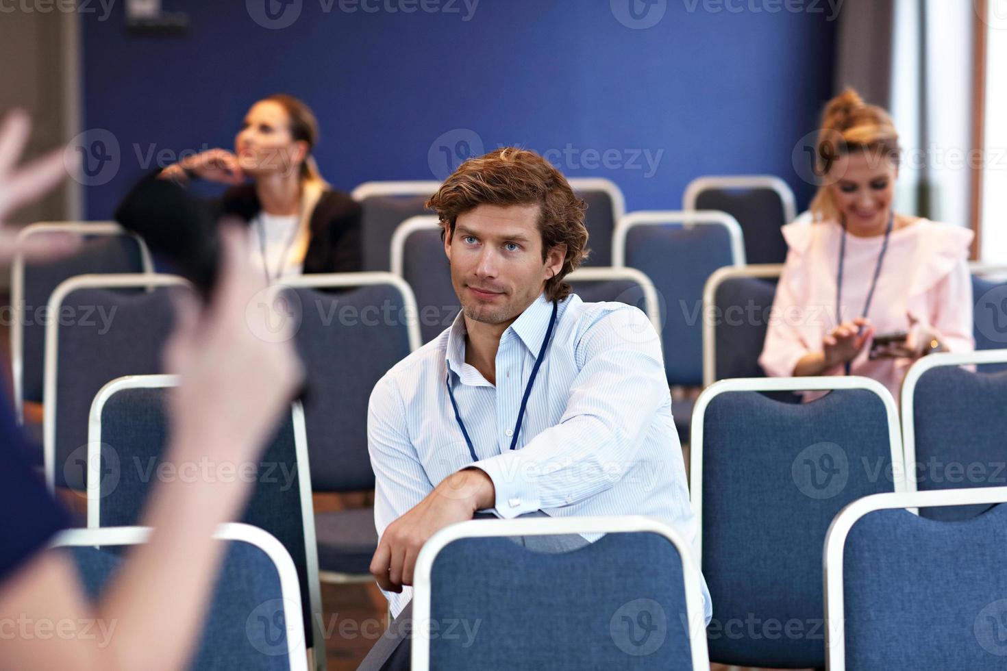 junge gelangweilte leute, die im konferenzraum sitzen foto