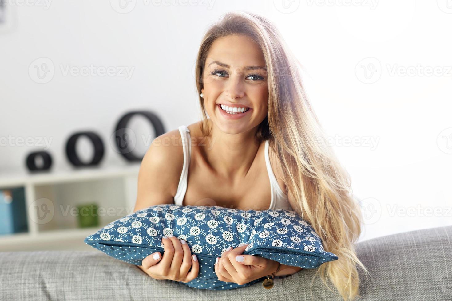 glückliche Frau, die auf dem Sofa ruht foto